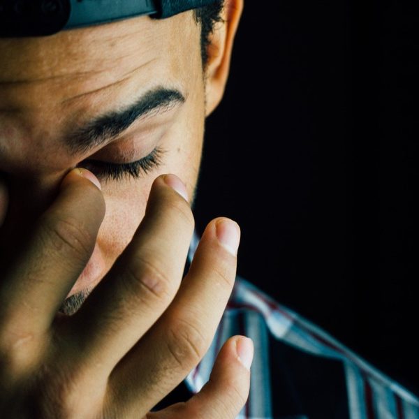 A man covering his face with his hands.