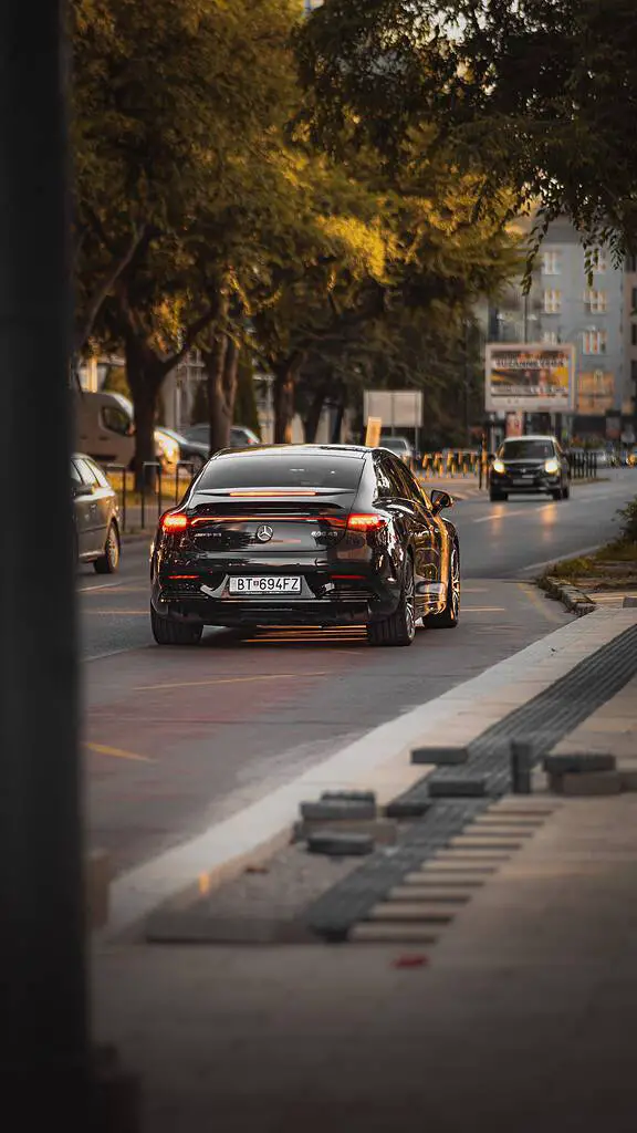 A black audi rs7 driving down a city street.