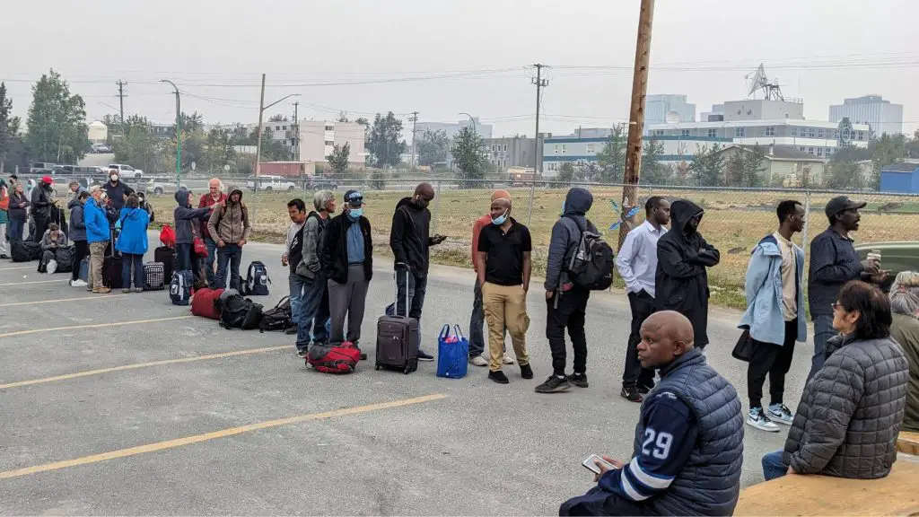A group of people standing in a line with luggage.