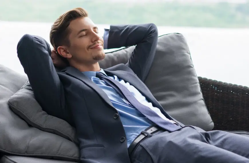 A man in a suit relaxes on a couch.